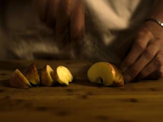 Photo of a apple being cut into wedges.